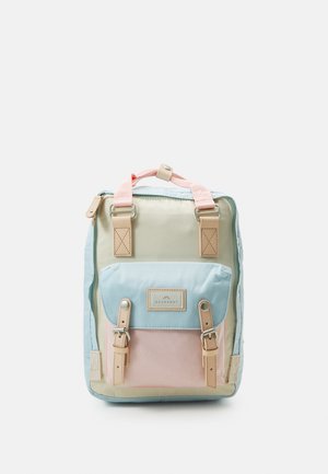 Petit sac à dos rectangulaire beige, bleu clair et rose avec poche à rabat avant et bretelles à boucles sur fond blanc.