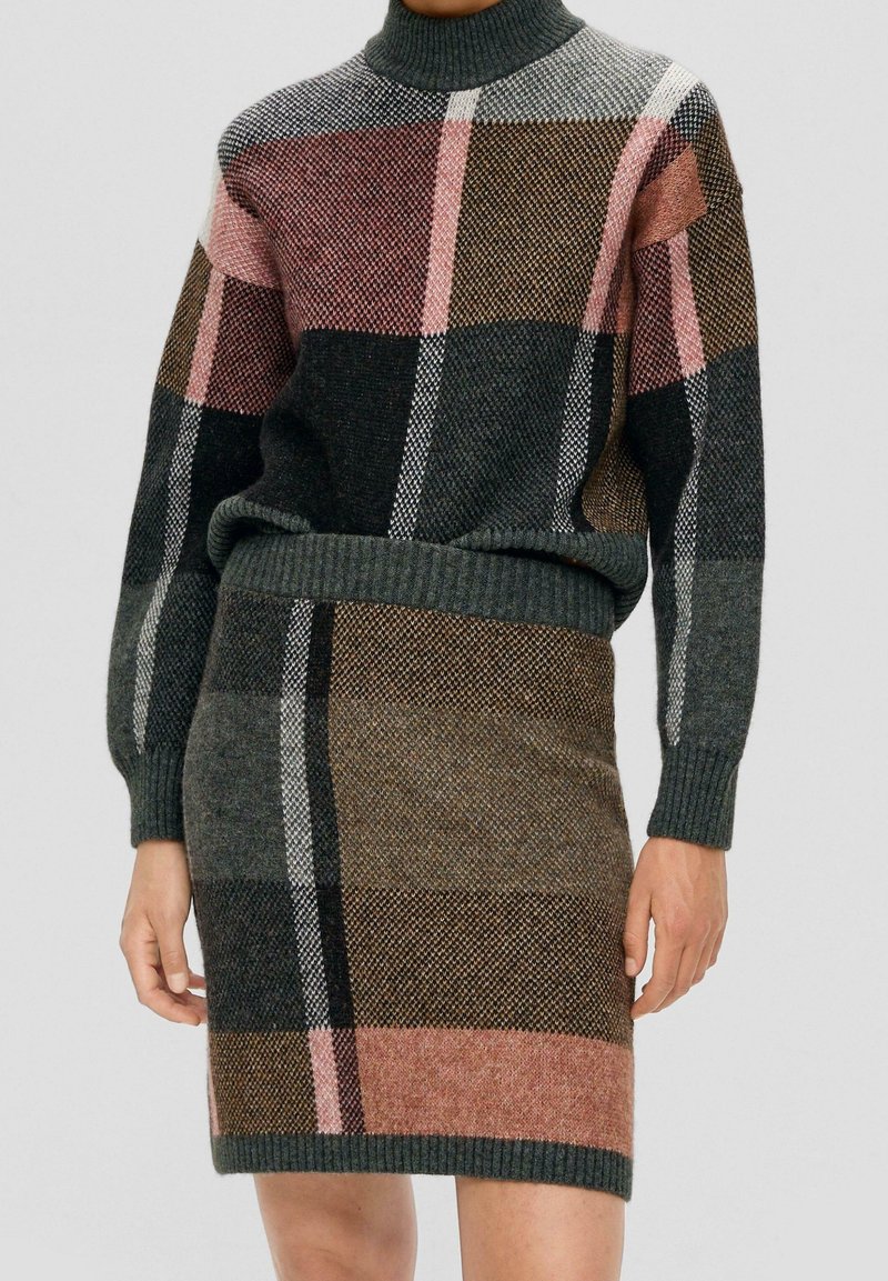 Ensemble pull col roulé et jupe avec grand motif à carreaux en tissu tricoté vert foncé, marron, rose et noir.
