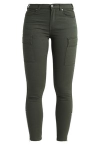 Groene cargobroek van rekbare stof. Beschikt over een slanke pasvorm, ritsen bij de enkels en twee voorkant cargozakken. Soepele textuur met minimale stiksels.