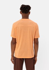 T-shirt arancione a maniche corte in tessuto mélange con maniche raglan, dotato di orlo dritto e di un discreto dettaglio del logo sul retro.
