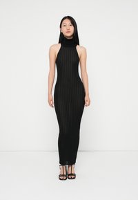 Μαύρο, εφαρμοστό φόρεμα με λαιμόκοψη halter, με ribbed υφή και μακρά σιλουέτα, που διαθέτει ψηλό γιακά και άνοιγμα στο στρίφωμα.