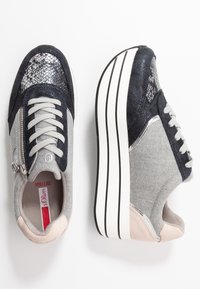 Sneakers featuring a mix of gray fabric and navy synthetic materials, metallic accents, a textured toe cap, and a thick white sole.