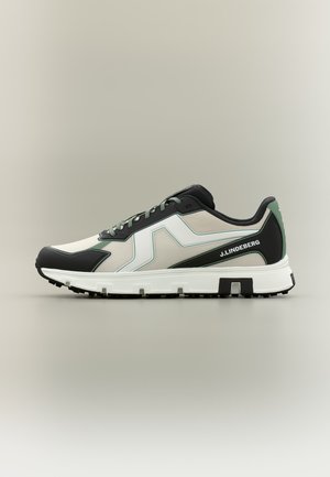 Low-top sneaker with white, black, and green panels, white textured sole, black laces, and "J.LINDEBERG" branding on side.