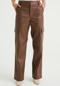 Bruna byxar i faux läder med sidofickor, rak ben-design och knappstängning, med en slät, glansig yta.