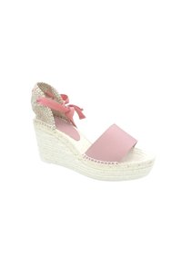 Sandalia de cuña con una tira frontal de cuero rosa, envoltura de tobillo de yute tejido en beige y suela de esparto trenzada. Diseño de punta cerrada.