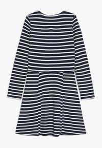 Sukienka z długim rękawem w granatowo-białe poziome paski, z okrągłym dekoltem i rozkloszowanym dołem, charakteryzująca się gładką bawełnianą teksturą.