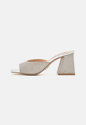 Open-toe block heel shoe in soft silver mesh with rhinestone embellishments, featuring a geometric chunky heel and smooth metallic accents.