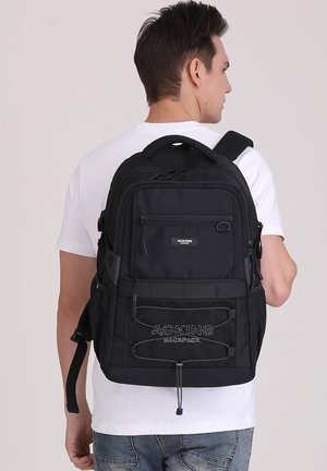 Zaino nero realizzato in tessuto resistente, dotato di più scomparti, tasche con zip e spallacci regolabili; logo ricamato sul fronte.