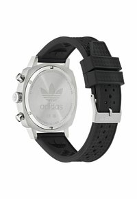 Adidas-klocka med boett i rostfritt stål, svart gummiband med texturerad design och ingraverad logotyp på baksidan. Silverfärgade detaljer.