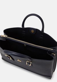 Borsa a tracolla in pelle blu navy con hardware dorato, superficie liscia, manici corti doppi e scomparto interno con zip. Dotata di chiusura magnetica.