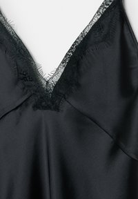 Czarna satynowa koszulka na ramiączkach z dekoltem w kształcie litery V, ozdobiona delikatną czarną koronką na krawędziach i lekko fakturowaną tkaniną.