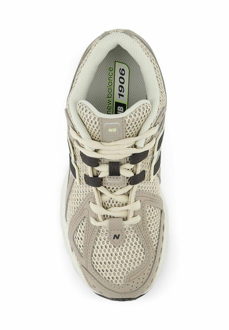 Scarpa sportiva beige con tomaia in rete, dettagli neri e lacci bianchi. Un logo è presente sulla linguetta e sul lato. Design leggero.