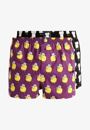 Lila und schwarze Boxershorts mit gelben, cartoonhaften Figuren mit Hüten. Die lila Variante hat ein wiederholtes Muster, während die schwarze einfarbig ist.