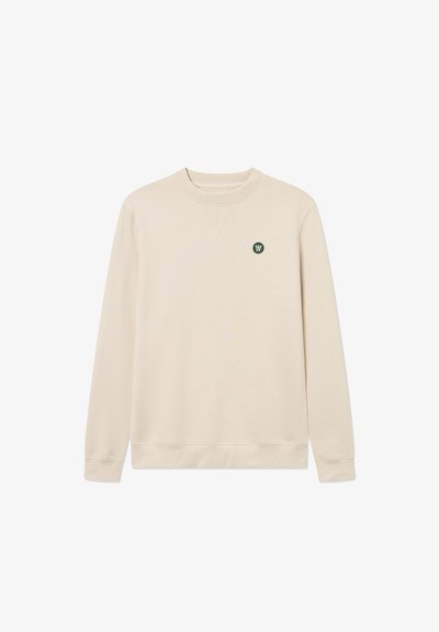 Beige Sweatshirt mit rundem Ausschnitt, langen Ärmeln und einem kleinen grünen Logo auf der linken Brust. Der Stoff ist glatt mit einer weichen Textur.