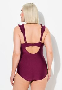 Maillot de bain une pièce prune avec des bretelles volantes, un dos nu et un tissu lisse et brillant. Doté de bretelles réglables et d'une coupe flatteuse.