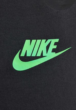 Canottiera nera in tessuto con un grande logo Nike verde e un design a swoosh, che mette in evidenza una texture liscia e un dettaglio grafico audace.
