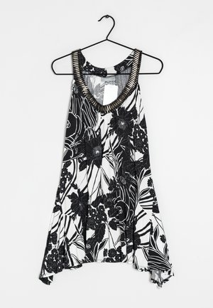 Czarny i biały kwiatowy top na ramiączkach o luźnym kroju, głęboki dekolt w kształcie litery V oraz teksturowany, metaliczny akcent w okolicy dekoltu. Lekka tkanina z kwiatowymi wzorami.