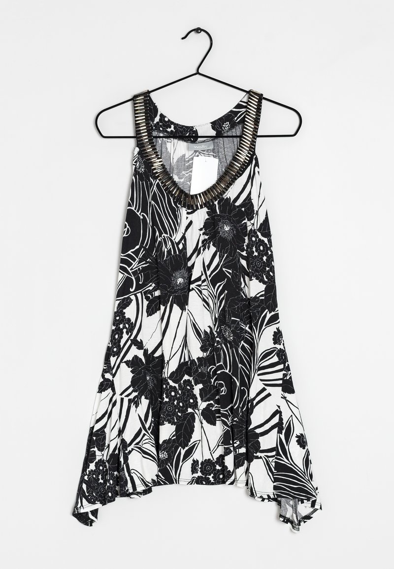 Débardeur floral noir et blanc avec une coupe ample, un décolleté en V profond et un col texturé rehaussé de métal. Tissu léger avec des motifs floraux.