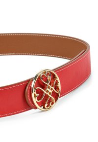Röd läderbälte med en slät yta, med en stor cirkulär spänne i guldton prydd med hjärtformer. Kontrastsydd i vitt.