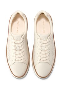 Vita sneakers i läder med perforerade detaljer, snörning och beige gummisula. Märkning präglad på tungan och innersulan.