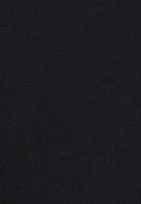 Surface texturée noire avec un motif tissé subtil et des lignes géométriques pâles.