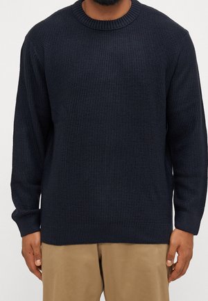 Marineblauer Strickpullover mit Rundhalsausschnitt, ausgestattet mit einem strukturierten Muster und langen Ärmeln, hergestellt aus einem weichen, dicken Material.