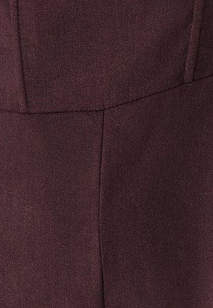 Burgundia kangas tekstuuri kudumisega, millel on sile viimistlus ja nähtavad õmblused. Näitab struktureeritud disaini, millel on õmbluse detailid.