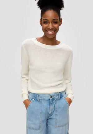 Helle, gestrickte Cremefarbenen Pullover mit weitem Ausschnitt und gerippten Bündchen, kombiniert mit hellblauen Denim-Shorts mit Fronttaschen.