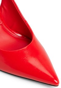 Scarpa in pelle rossa a punta, con una superficie liscia e design a scollo basso, che mette in risalto una silhouette elegante e una finitura lucida.