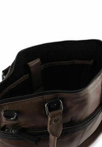 Bruine leren tas met een bovenrits, voorzien van een zwarte stoffen voering en zichtbare metalen details zoals gespen en stikaccenten.