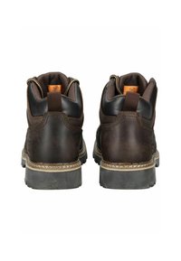 Botas de cuero marrón con un cuello acolchado, tirador y costuras en contraste en la suela. Acabado texturizado y patrón de suela duradera.