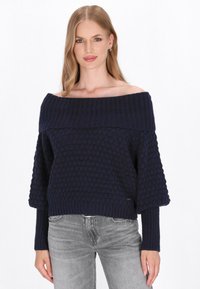 Maglione lavorato a maglia blu navy con design scivolato sulle spalle, scollo a coste e motivo a pois testurizzati. Maniche ampie e polsini aderenti.