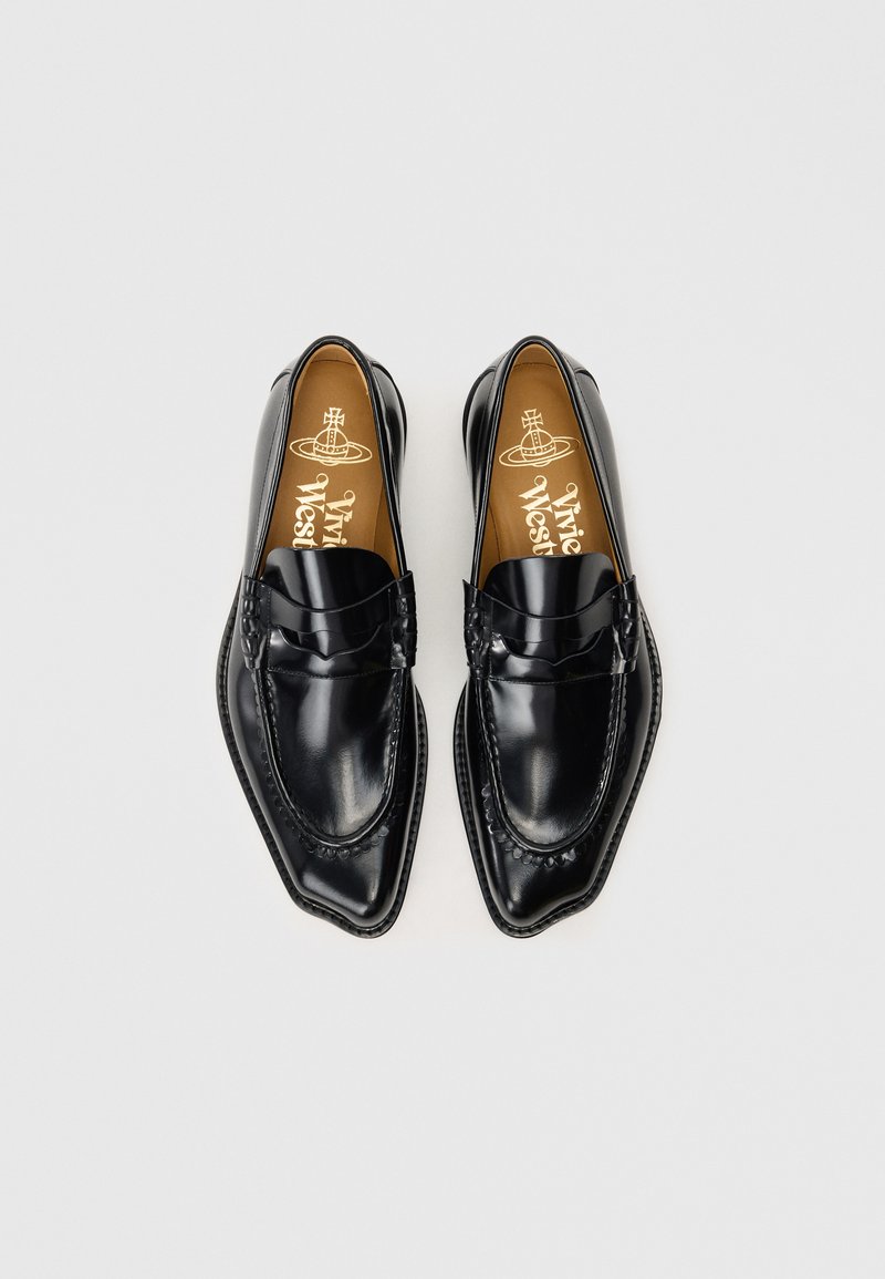 Mocassini in pelle nera con punta affusolata, caratterizzati da una finitura liscia e cuciture decorative lungo i bordi. Soletta color tan con marchio.