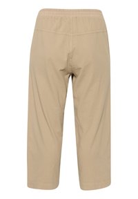 Des pantalons capri beiges en tissu doux présentent une taille élastique, une longueur raccourcie et une texture lisse avec de simples détails de couture.