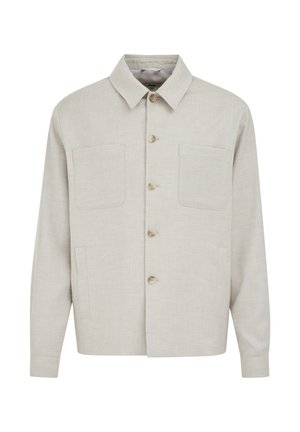 Svijetlo bež košulja dugih rukava s dvije zakrpe na prsima, oštrim ovratnikom i ravnim rubom.