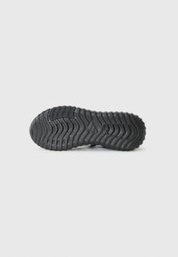 Semelle de chaussure en caoutchouc noir avec un motif de vagues texturé et un logo, conçue pour l'adhérence et la durabilité. Bords plats et arrondis.