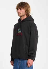 Zwarte hoodie gemaakt van een gemixte katoenstof. Beschikt over een voorzak en geborduurde grafische details in groen en rood op de borst.