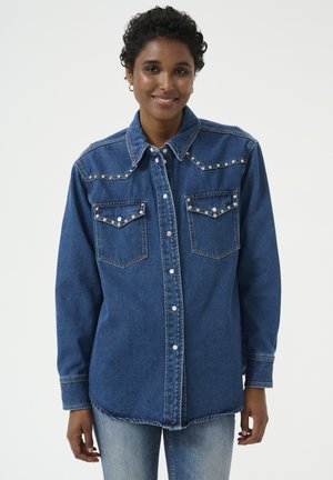Dunkelblaue Jeanshemd mit Druckknöpfen, dekorativen Nähten und zwei vorderen Taschen mit steinartigen Akzenten. Lange Ärmel.