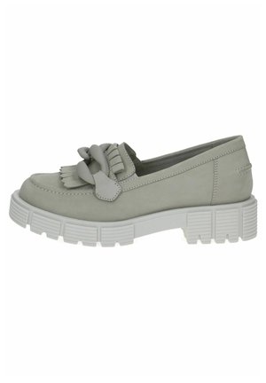 Scarpa slip-on grigia chiara con suola bianca spessa, caratterizzata da un fiocco decorativo e dettagli frangiati sulla parte anteriore. Texture liscia, punta arrotondata.