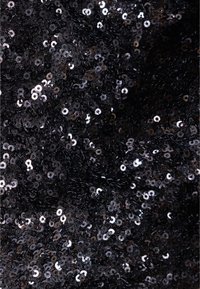 Czarna tkanina z cekinami, pokryta błyszczącymi, okrągłymi cekinami gęsto ułożonymi, tworzącymi teksturowaną i odbijającą powierzchnię.