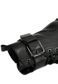 Černá kožená bota s páskem na přezku, kulatými tkaničkami a kovovými doplňky. Hladká textura s elegantním designem a jemnými detaily stehů.