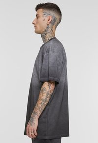 Rövid ujjú, crew nyakú, szürke színátmenetes, pamut keverék anyagú oversized póló, puha tapintással, jellemzően laza szabású.