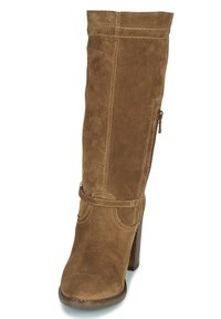 Botte haute en daim brun jusqu'au genou avec talon bloc, présentant des coutures diagonales, une fermeture éclair latérale et une bride décorative autour de la cheville.