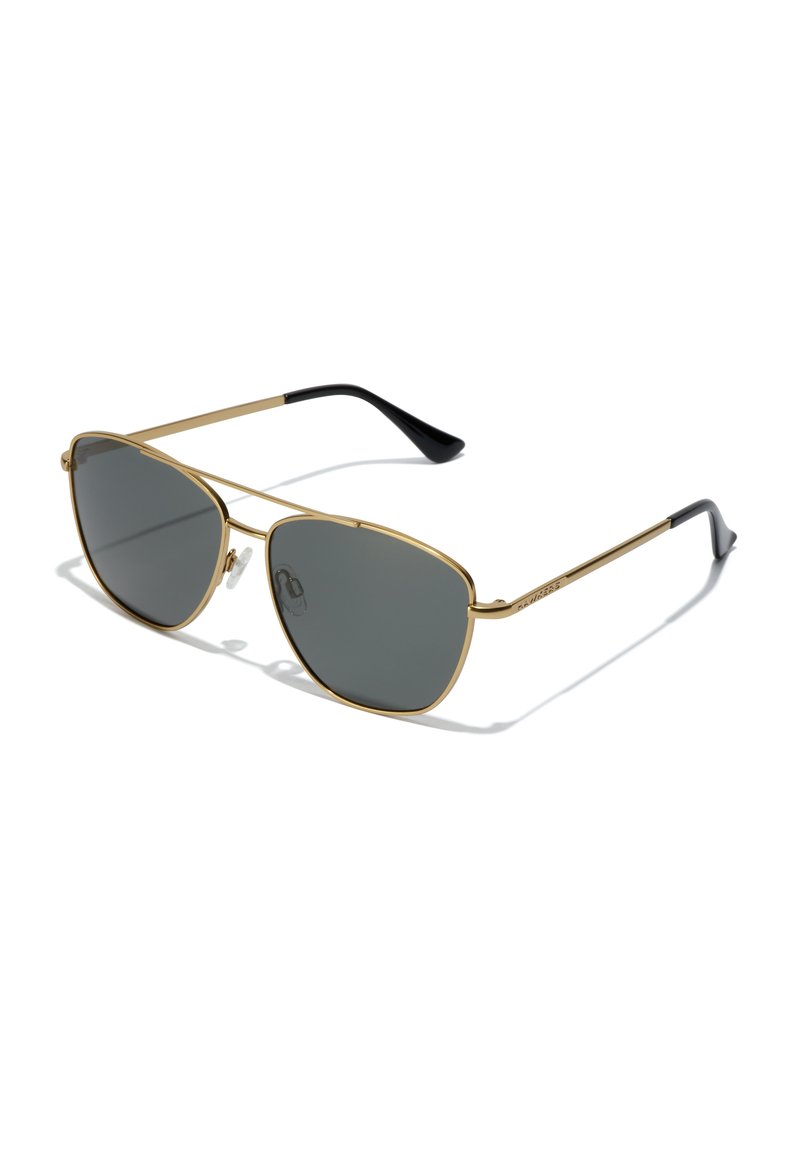 Ochelari de soare din metal auriu cu lentile gri, de formă ovală, cu rame subțiri și vârfuri negre pe brațe. Include suporturi pentru nas ajustabile pentru confort.