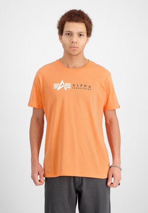 Oranges Baumwoll-T-Shirt mit Rundhalsausschnitt, kurzen Ärmeln und einem in Grau und Weiß gedruckten Logo auf der Vorderseite. Schlichter Hintergrund.