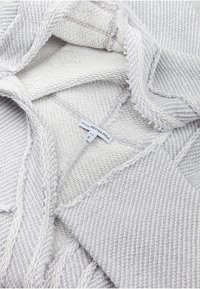 Grå og hvidstribet strikket sweater med en blød tekstur, der har en sømdetalje og et mærke, der viser "BETTER RICH" og størrelse S.