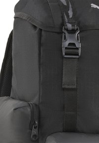 Zaino nero in tessuto testurizzato, con spallacci regolabili e una tasca laterale con zip e linguetta per un facile accesso.