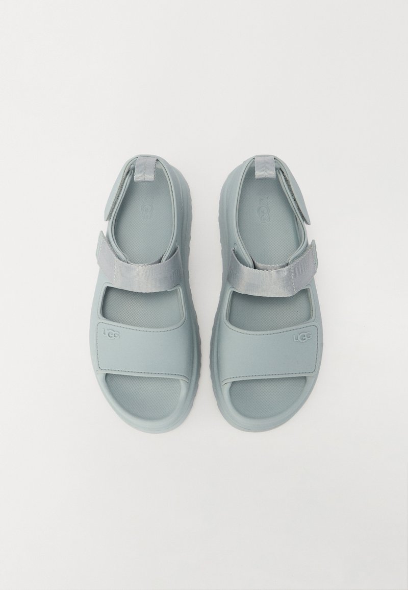 Sandali azzurri chiari realizzati in materiale sintetico, con cinturini regolabili, design open toe e soletta testurizzata per una migliore aderenza.