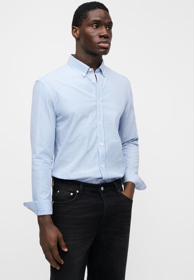 Lyseblå og hvide stribet skjorte med knapper, krave, lange ærmer og manchetter, båret med sorte jeans. Tekstureret stof, skræddersyet pasform.