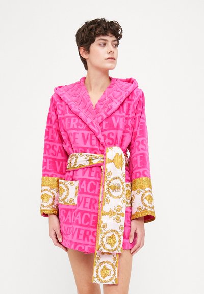 Accappatoio rosa in plush con logo "VERSACE" in rilievo, dotato di maniche, cintura e tasche con dettagli ornamentali in oro.